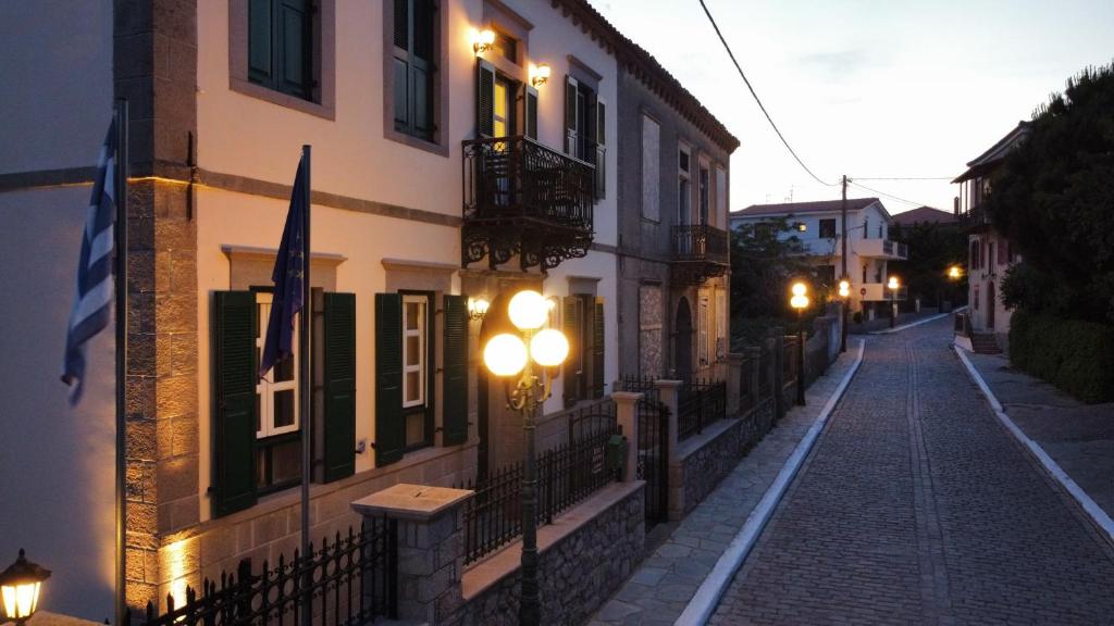 an empty street at night with buildings and lights at Artemis Traditional Hotel in Myrina
