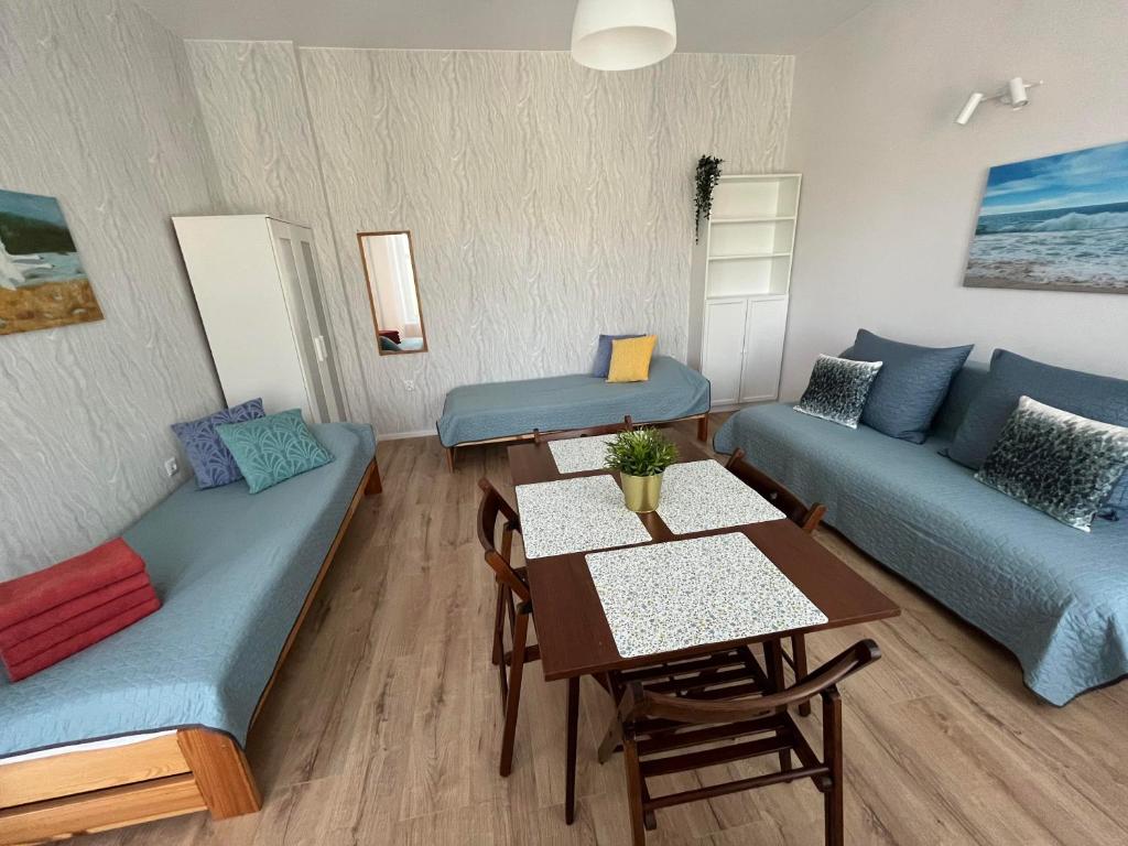 グダニスクにあるAla Apartmentのリビングルーム(青いソファ、テーブル付)