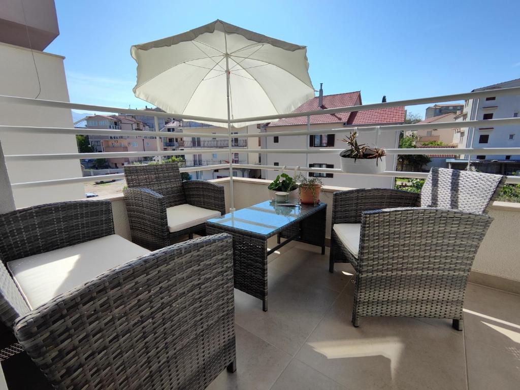 balcón con mesa, sillas y sombrilla en Lucy Apartment Split en Split