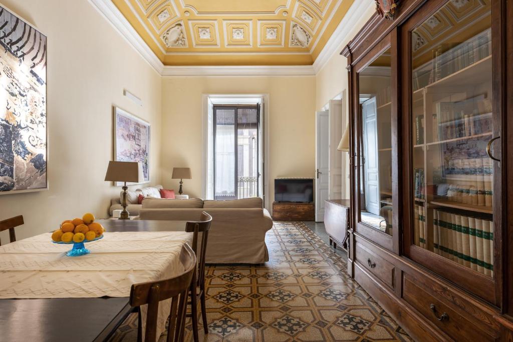 uma sala de estar com uma mesa e um sofá em Catania City Center Historical Building Home em Catânia