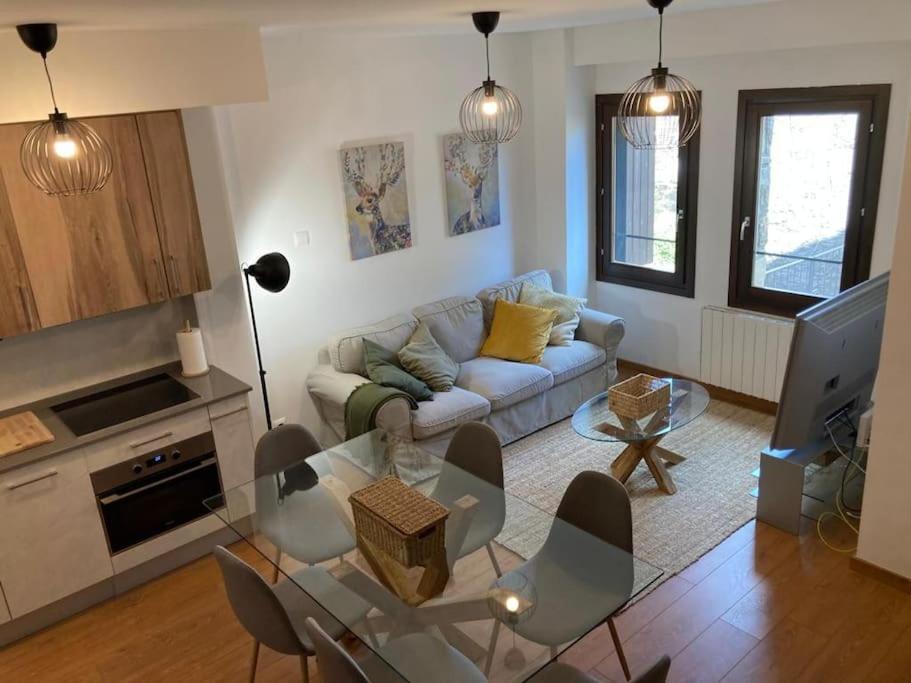 un soggiorno con un divano e un tavolo di vetro di Casa rural con encanto en Hecho a Hecho