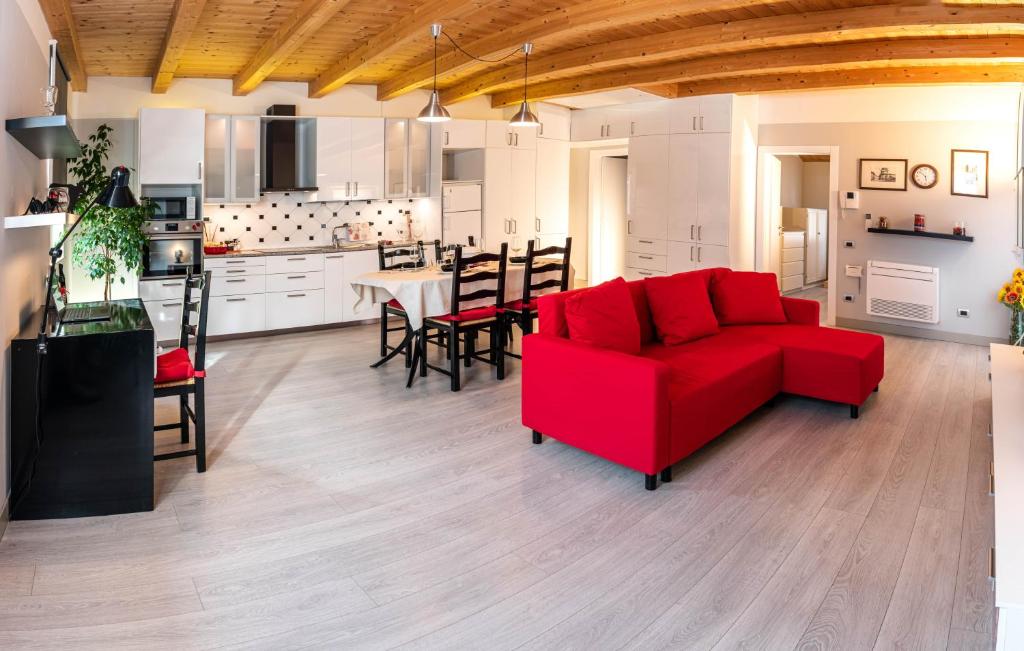 ein Wohnzimmer mit einem roten Sofa und einer Küche in der Unterkunft Appartamento incantevole con parcheggio privato in Casteldidone