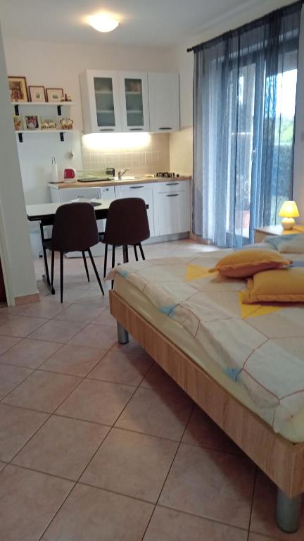 Una cama grande en una habitación con cocina. en Apartments Radović, en Labin