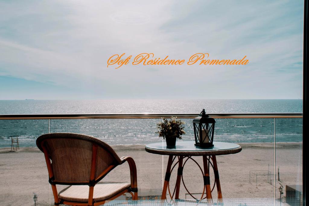 Sofi Residence Promenada في مامايا نورد نافورداي: طاولة وكرسي أمام الشاطئ