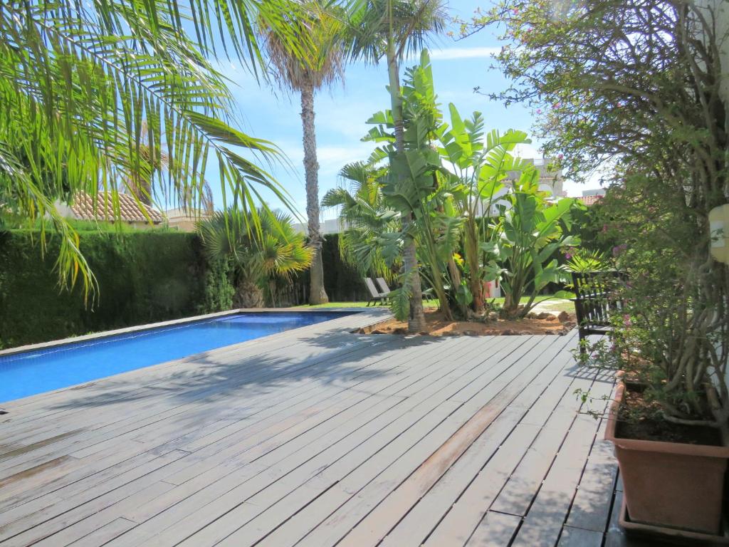 a backyard with a wooden deck and a swimming pool at Casa Azahar y Casa Buganvilla in Gandía