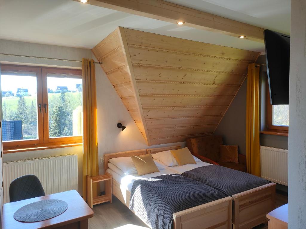 een slaapkamer met een bed en een groot raam bij Bafia - pokoje gościnne in Bukowina Tatrzańska