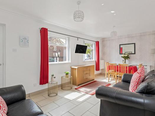 a living room with two couches and a dining room at Self Catering Belfast Apartment in Belfast