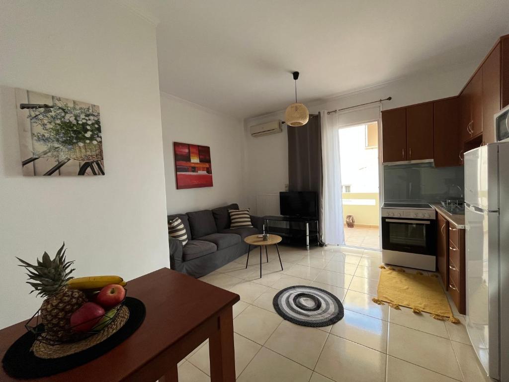 cocina y sala de estar con sofá y mesa en Seaside cozy apartment, en Ayiá
