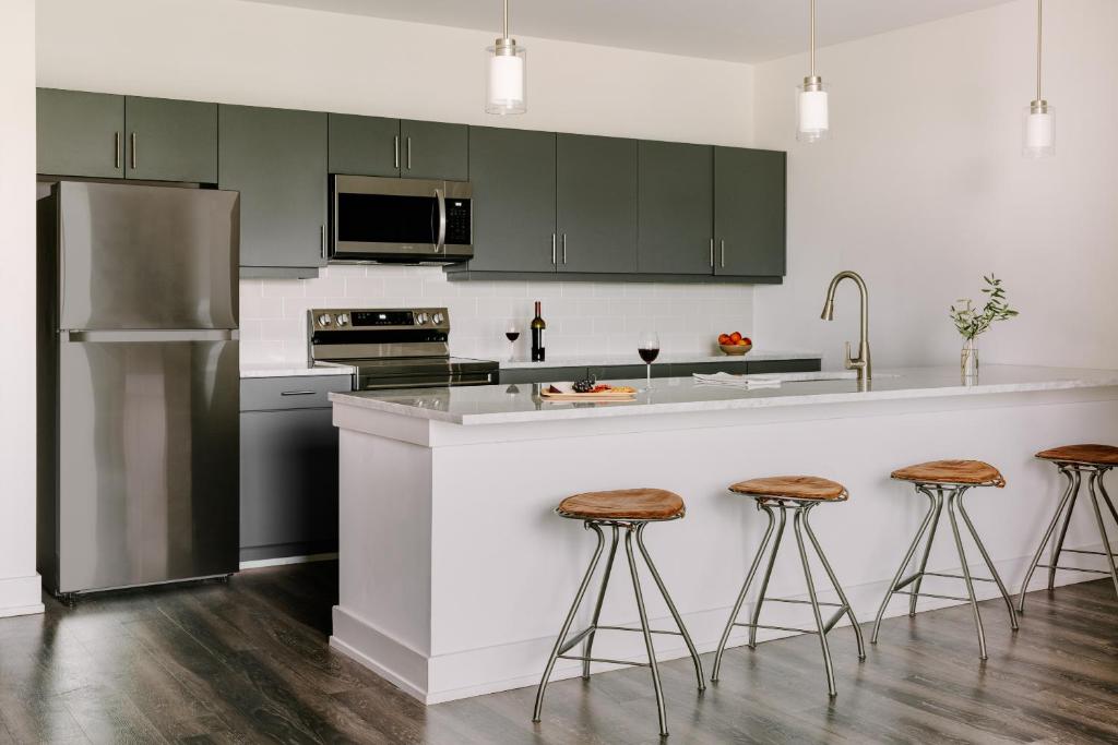 a kitchen with green cabinets and a counter with stools at Sonder Midtown South in Atlanta