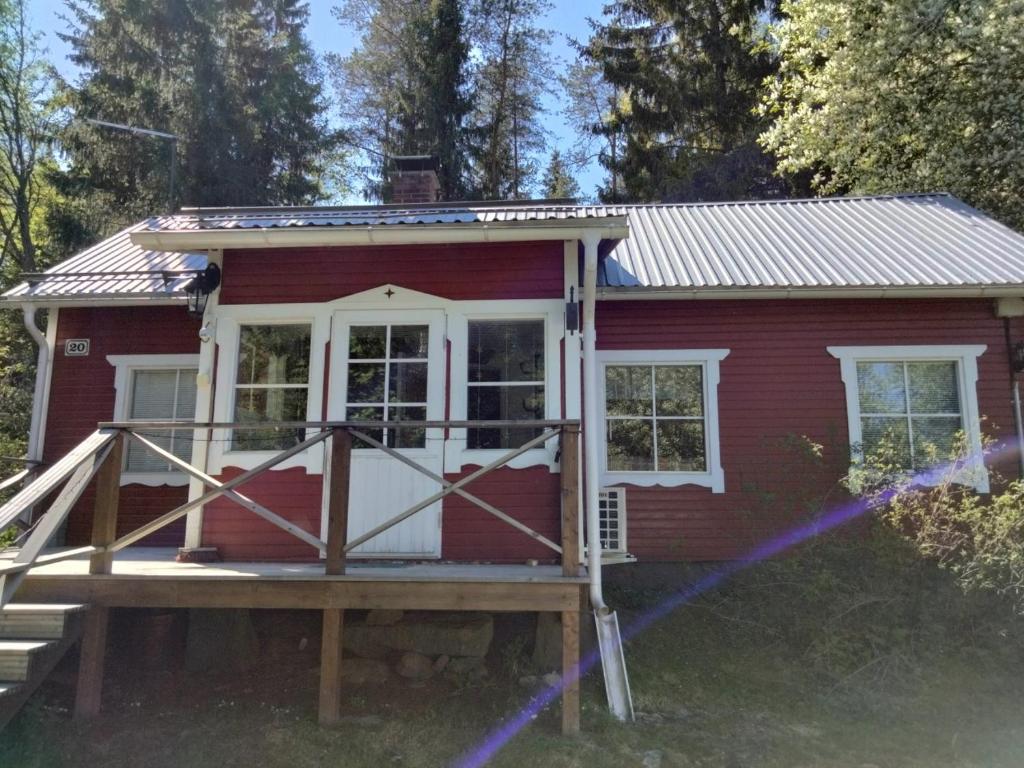 een rood tiny house met een veranda bij Mummola in Taluskylä