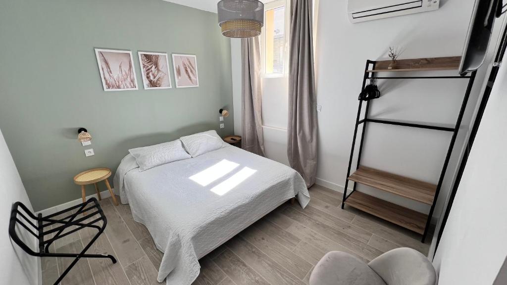 a small bedroom with a bed and a ladder at Hotel Restaurant Les Paquebots in Port-Vendres