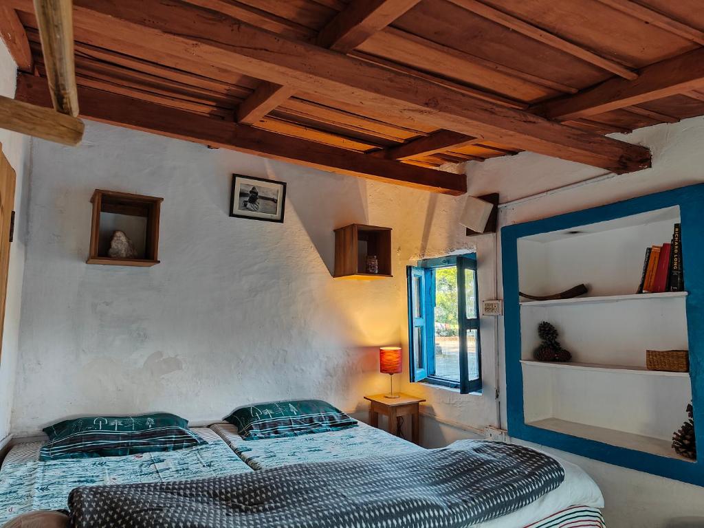 una camera con letto in una stanza con soffitti in legno di Turiya niwas Kasar Devi ad Almora