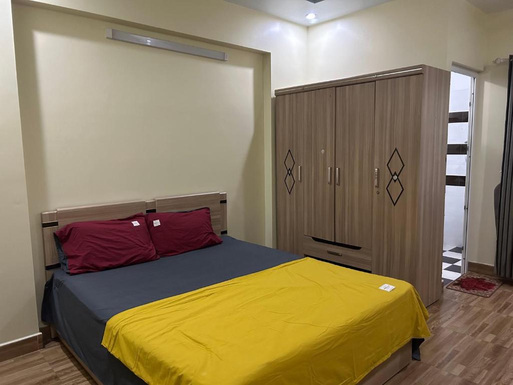a bedroom with a bed with a yellow blanket and a closet at S23 homestay in Hai Phong
