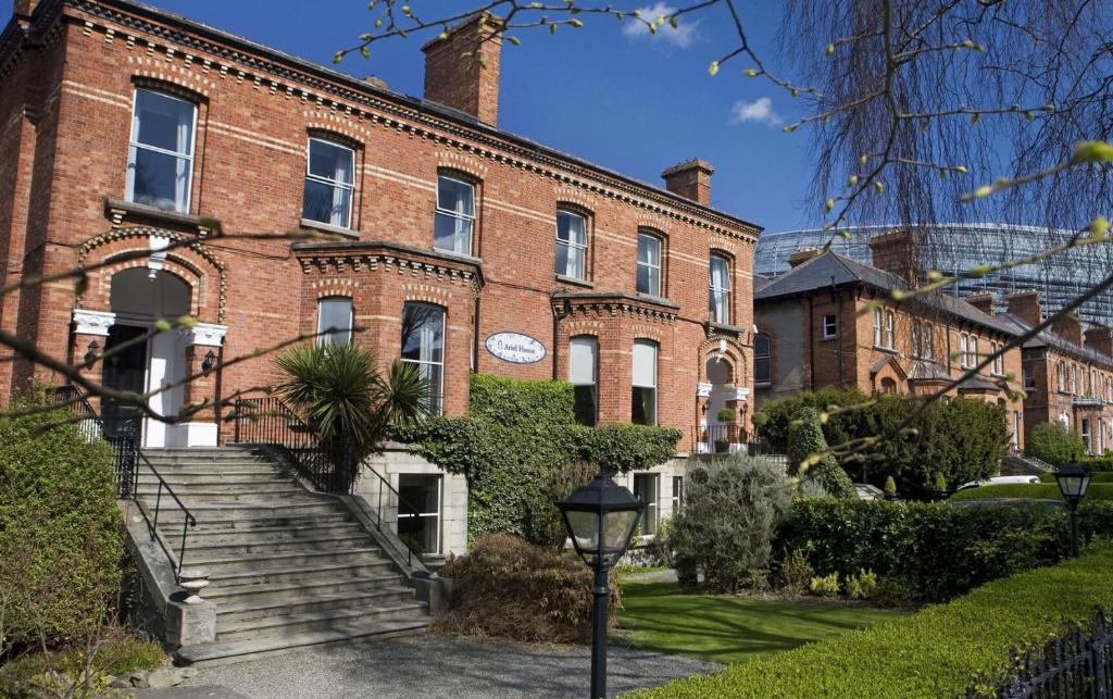 Un grand bâtiment en briques avec un escalier se trouve devant. dans l'établissement Ariel House, à Dublin