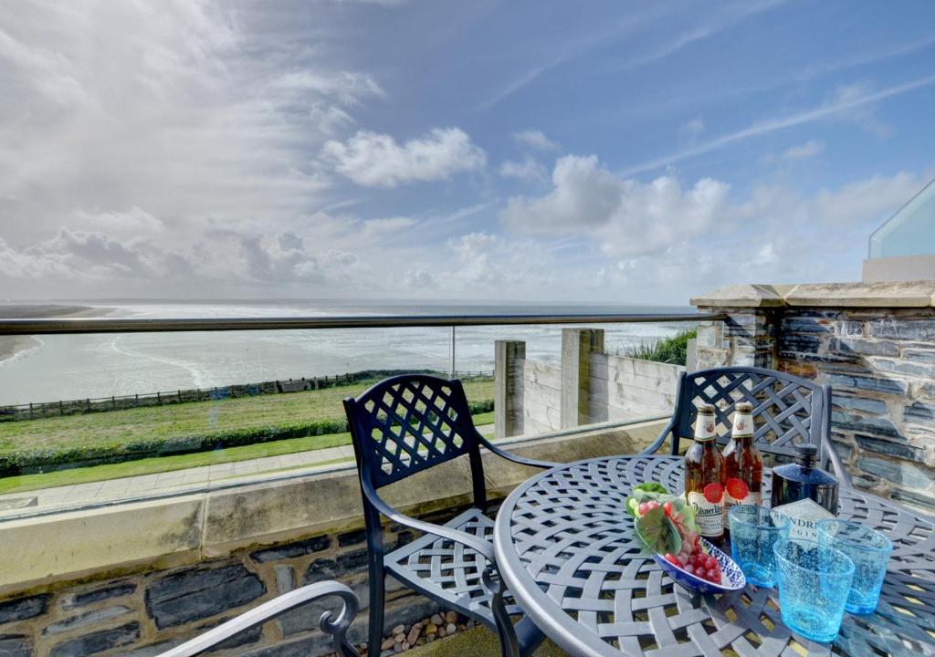 uma mesa e cadeiras numa varanda com vista para o oceano em 2 Ocean Point em Braunton