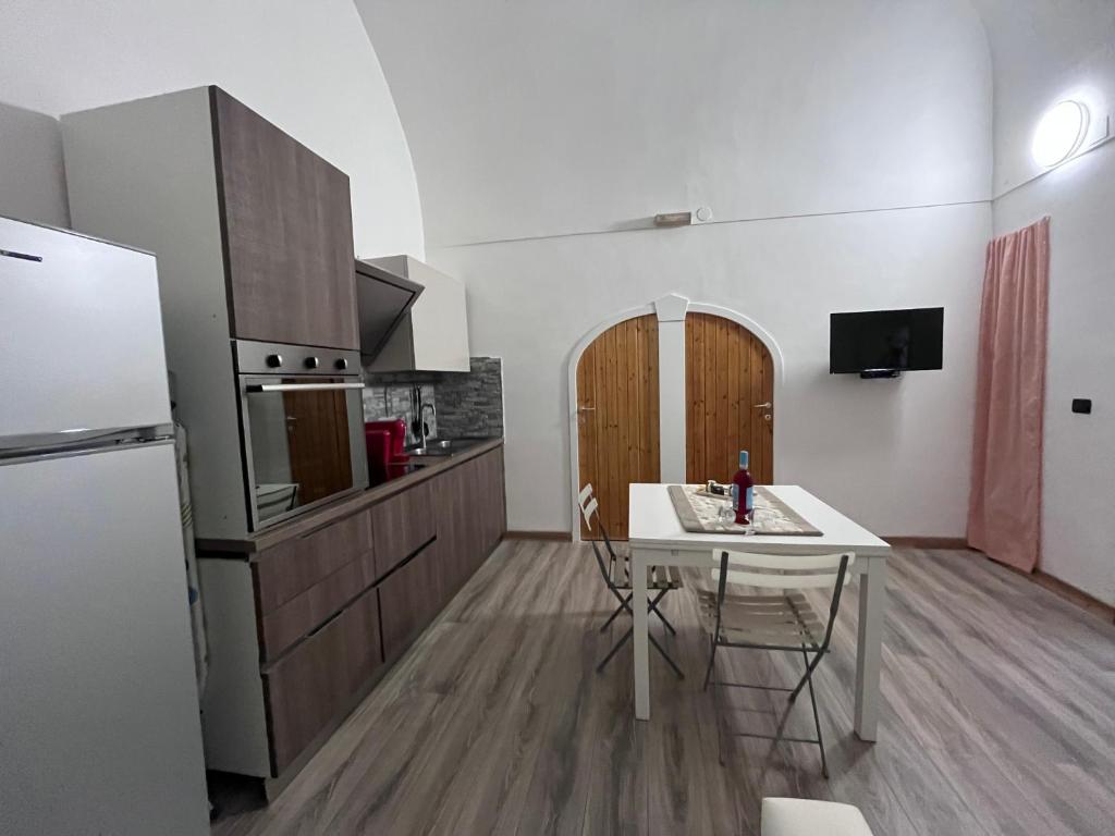 ローディ・ガルガーニコにあるCasa vacanze la voltaのキッチン(白いテーブル、白い冷蔵庫付)