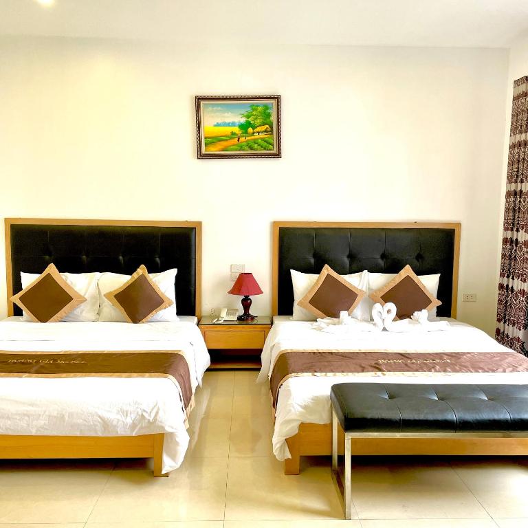 Habitación de hotel con 2 camas y mesa en Hoàng Gia Hotel en Hanói