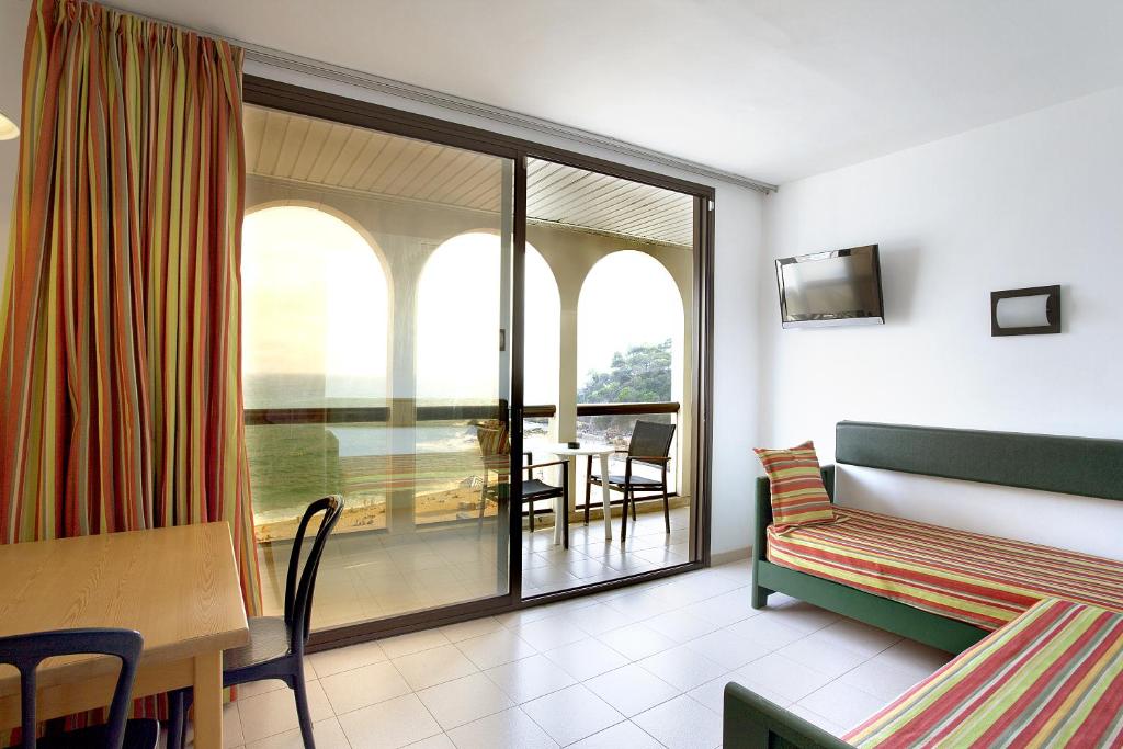 
a hotel room with two beds and a table at Apartaments Rosanna in Lloret de Mar
