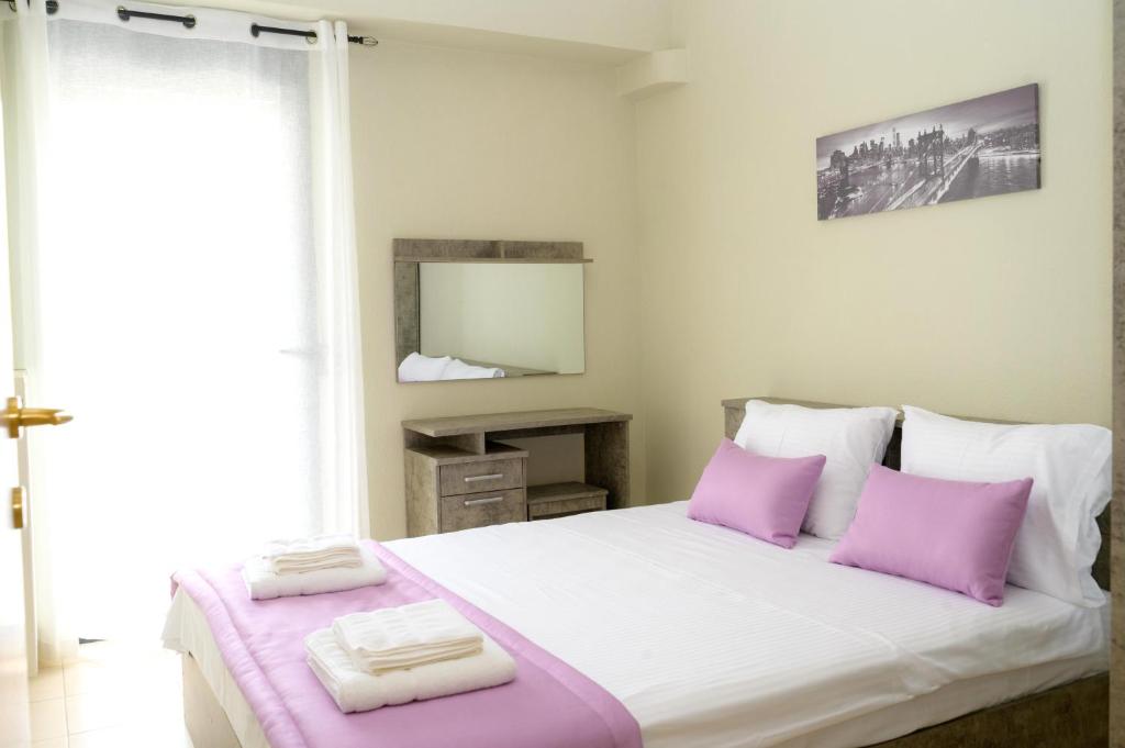 ein Schlafzimmer mit einem großen Bett mit lila Kissen in der Unterkunft Sunshine Apartments #01 in Thessaloniki