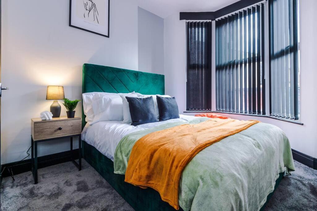a bedroom with a large bed and a window at Mansa Musa House - 5 Bed 5 En Suite Bathrooms, Newly Refurbished House with free parking outside in Liverpool