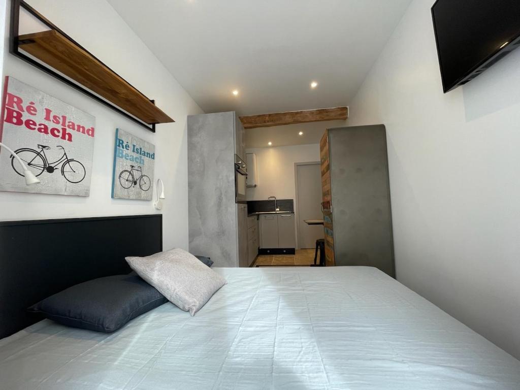 une chambre avec un grand lit dans une pièce dans l'établissement Le St Louis 1 Chambre aménagée avec cuisine, à La Rochelle