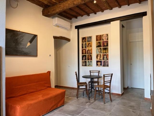 sala de estar con sofá, mesa y sillas en Appartamento Il Picchio Verde, en Altopascio