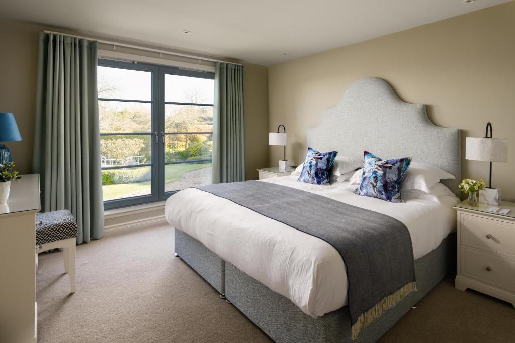 a bedroom with a large bed and a large window at The Peat Inn Restaurant With Rooms in St Andrews