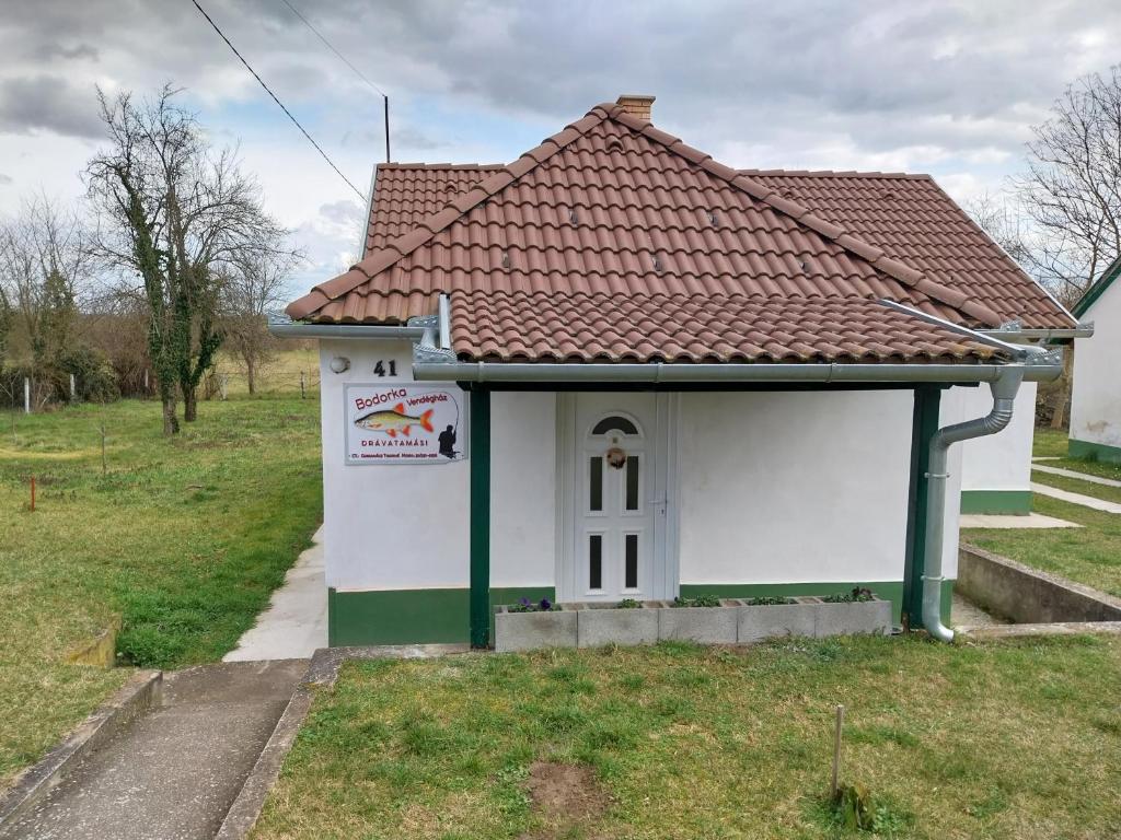 un pequeño edificio blanco con techo rojo en Veronika Guesthouse en Drávatamási