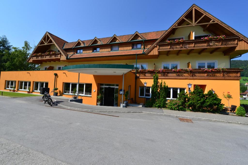 ein Gebäude mit einem Motorrad, das davor geparkt ist in der Unterkunft Hotel Angerer-Hof in Anger