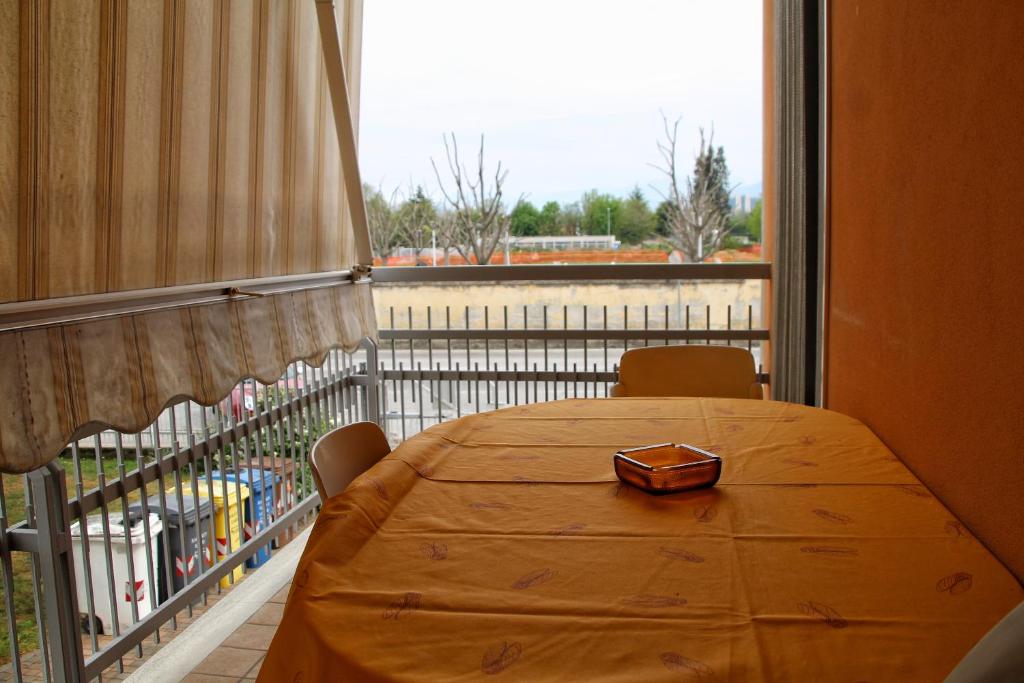 een houten tafel op een balkon met een groot raam bij RITA & GIO in Cuneo