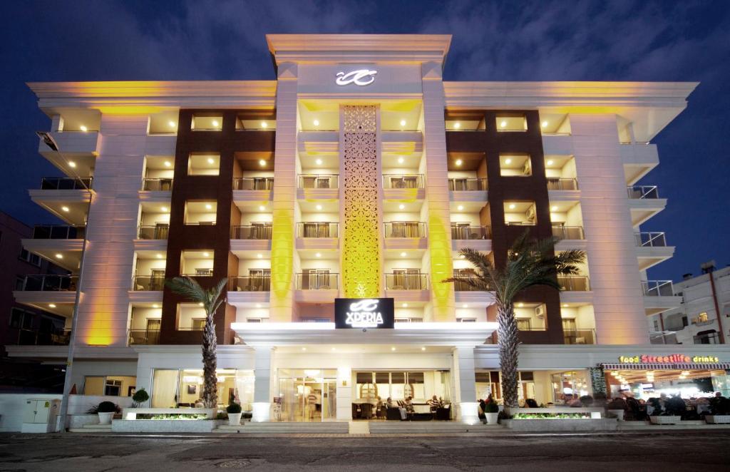 a hotel with a lit up facade at night at Xperia Grand Bali Hotel - All Inclusive in Alanya