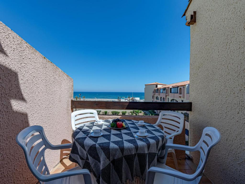 a table and chairs on a balcony with a view of the beach at Apartment Front de Mer-8 by Interhome in Le Barcarès