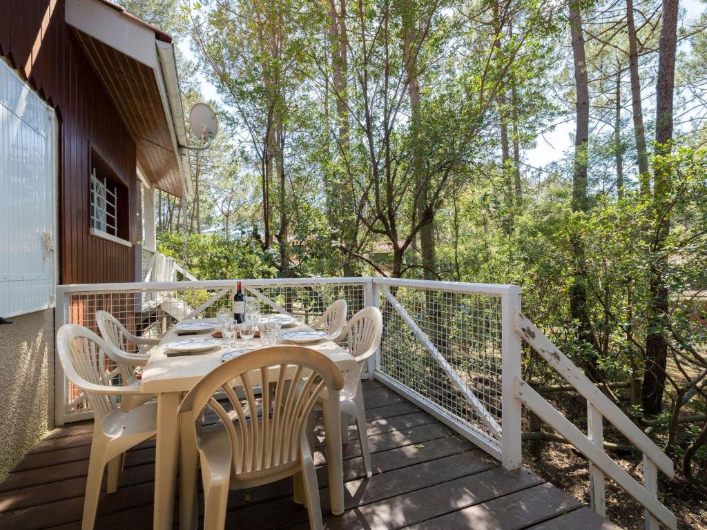 a patio with a table and chairs on a deck at Holiday Home Golf Loisirs-4 by Interhome in Lacanau-Océan
