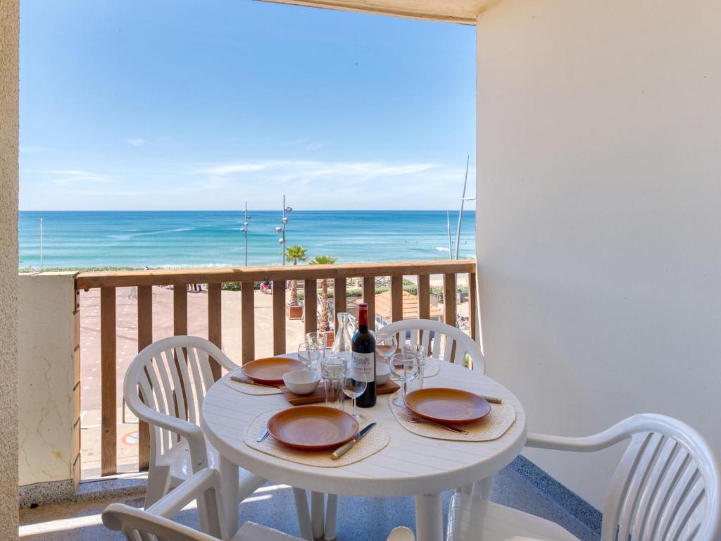 a white table with chairs and a table with a view of the ocean at Apartment Ortal Océan-2 by Interhome in Lacanau-Océan