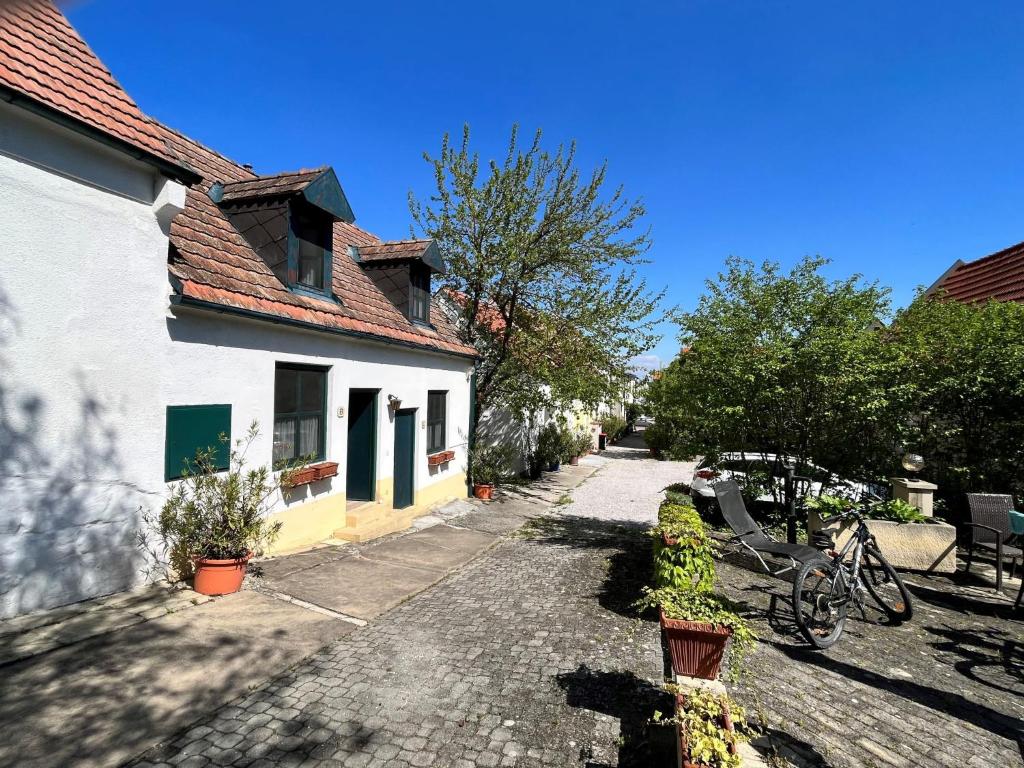 a cobblestone street in front of a white house at Holiday Home Hofgasse - MOE112 by Interhome in Mörbisch am See