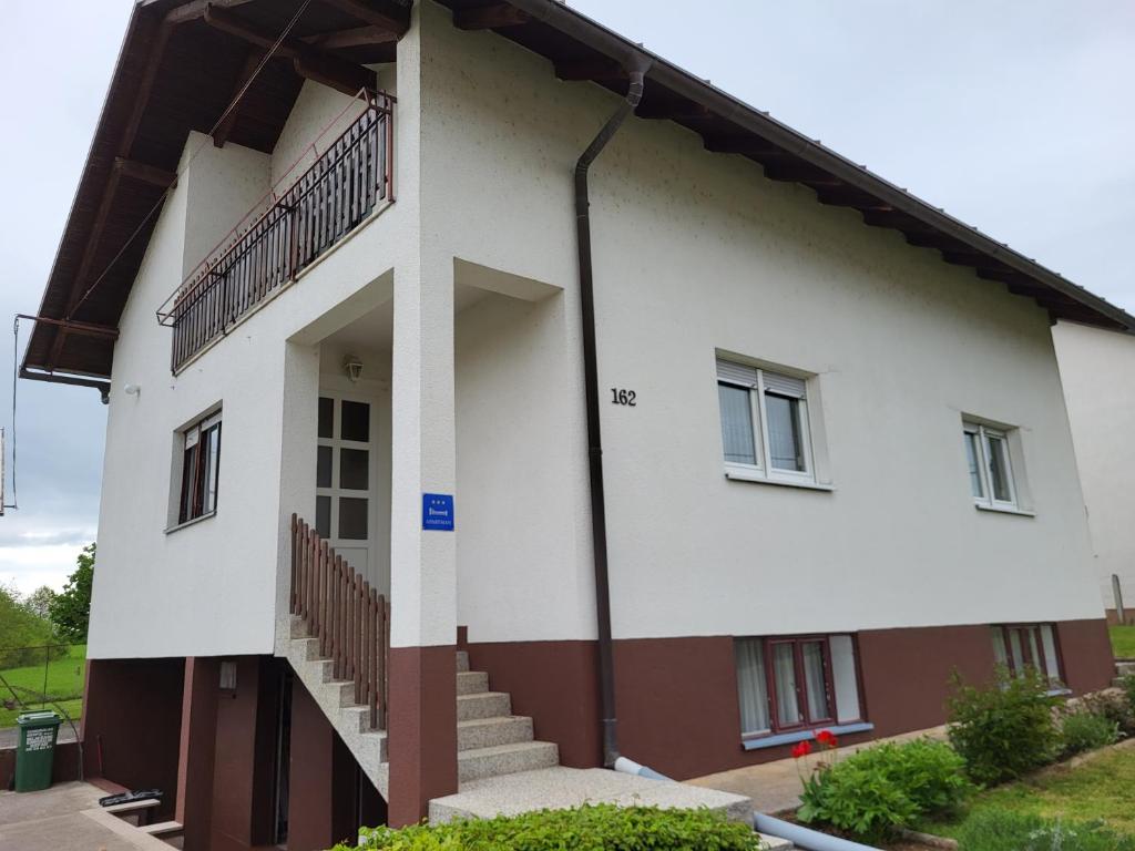 a white building with stairs on the side of it at Apartman Martina in Gospić