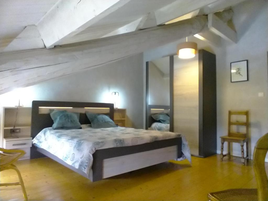 ein Schlafzimmer mit einem großen Bett in einem Zimmer in der Unterkunft La grange à Tissac in Cazes-Mondenard