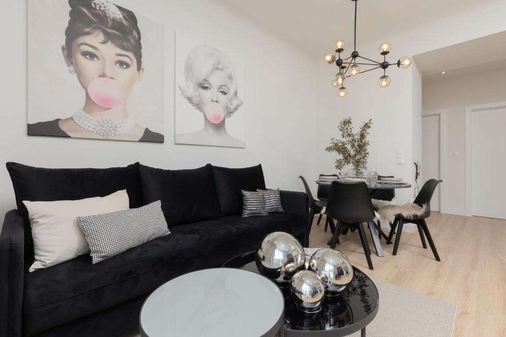 Fashionable City Center Apartment by Renters في وارسو: غرفة معيشة مع أريكة سوداء وطاولة