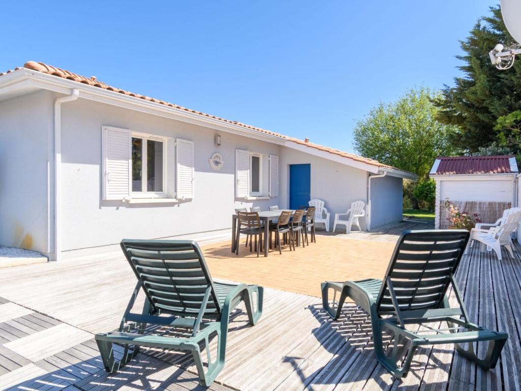 une terrasse avec des chaises et une table ainsi qu'une maison dans l'établissement Holiday Home La Clairière - BPL510 by Interhome, à Enhil