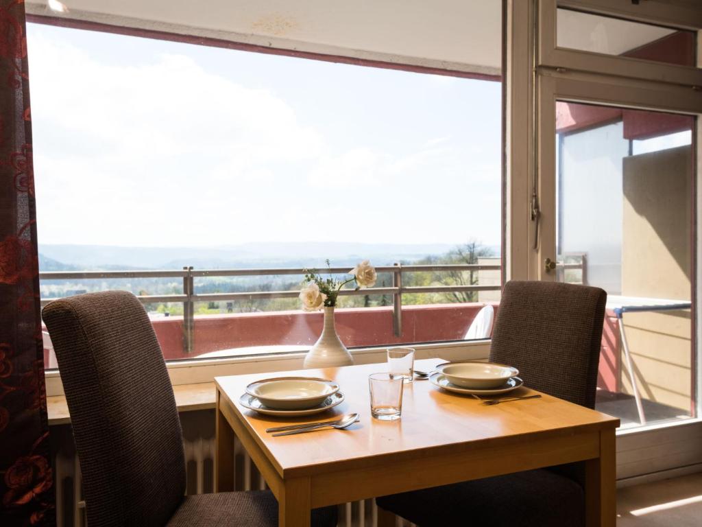 einen Esstisch mit Stühlen und ein großes Fenster in der Unterkunft Apartment B715 by Interhome in Lahnstein