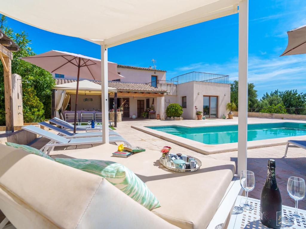 a villa with a swimming pool and a house at Holiday Home Es Cos by Interhome in Moscari