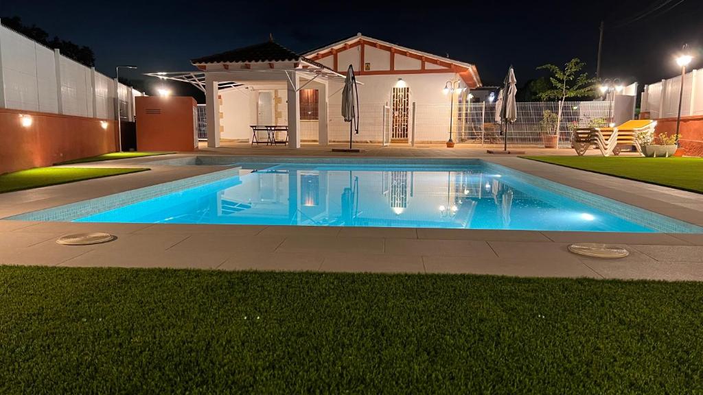 una piscina frente a una casa por la noche en CA LA LOLA, en Banyeres del Penedés