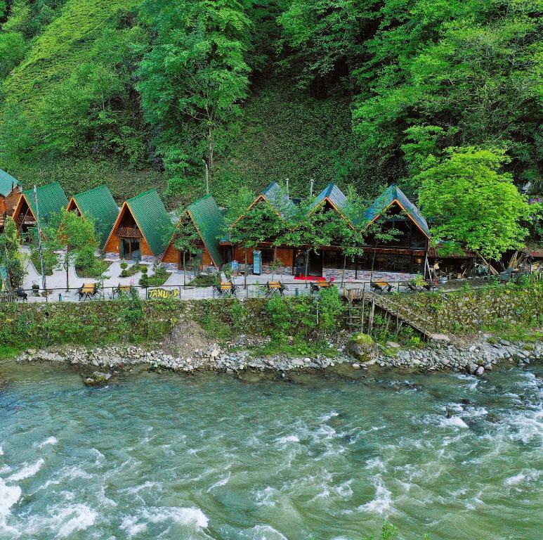 a row of houses next to a river at Tanura Bungalows in Çamlıhemşin