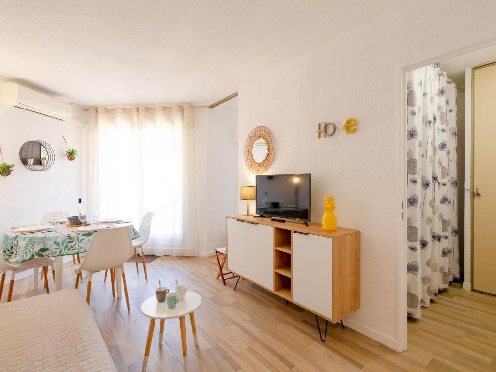 a living room with a television and a dining room table at Apartment Régina-13 by Interhome in Sainte-Maxime