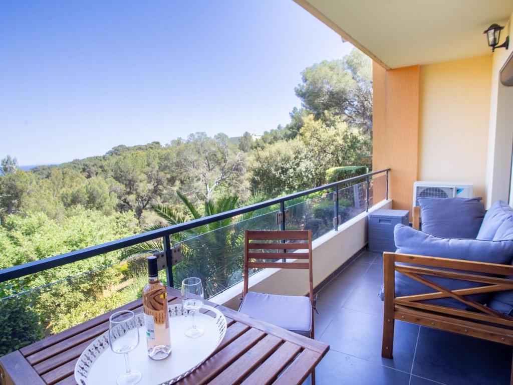 a balcony with a table with wine glasses on it at Apartment Un autre jour ensoleillé by Interhome in Bormes-les-Mimosas