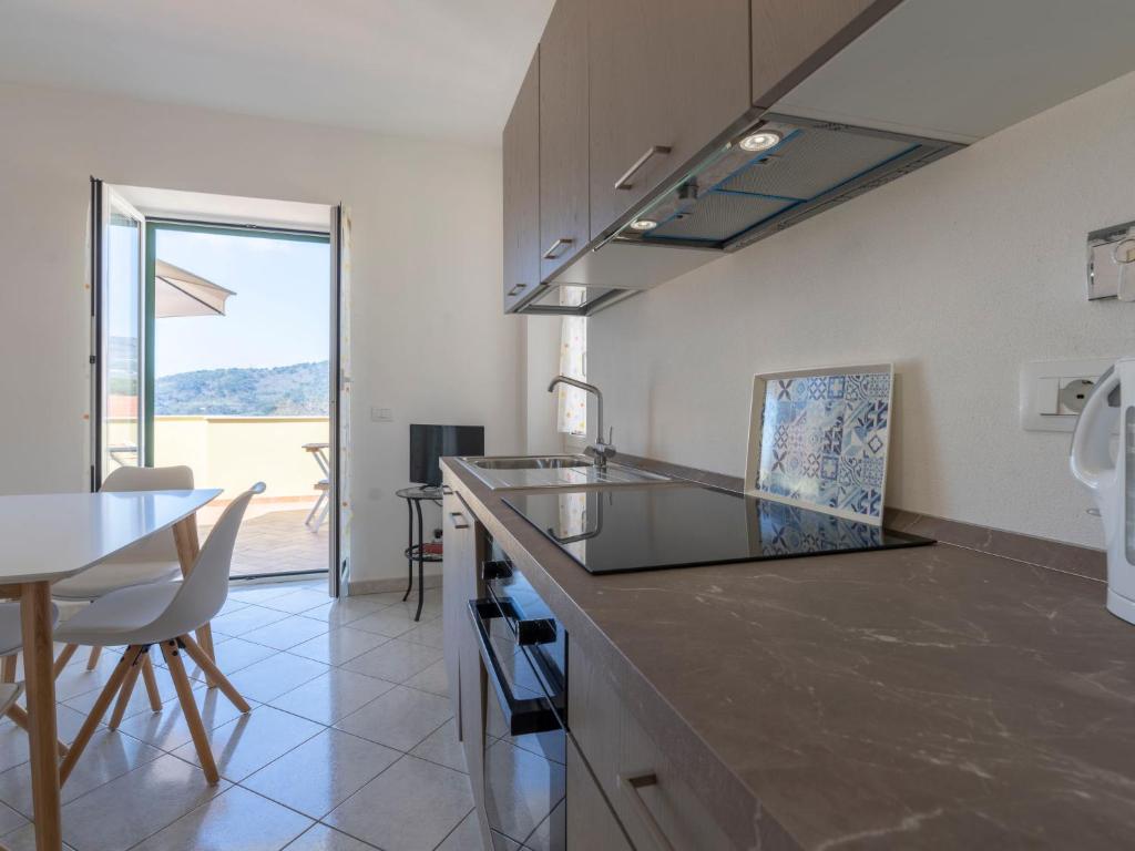 kuchnia z blatem i stołem oraz jadalnia w obiekcie Apartment Rosmarino by Interhome w mieście Chiappa