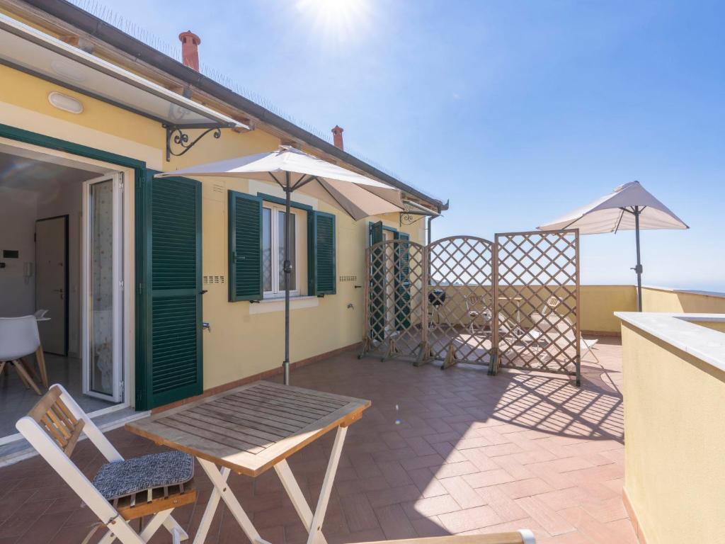 patio z drewnianym stołem i parasolem w obiekcie Apartment Rosmarino by Interhome w mieście Chiappa