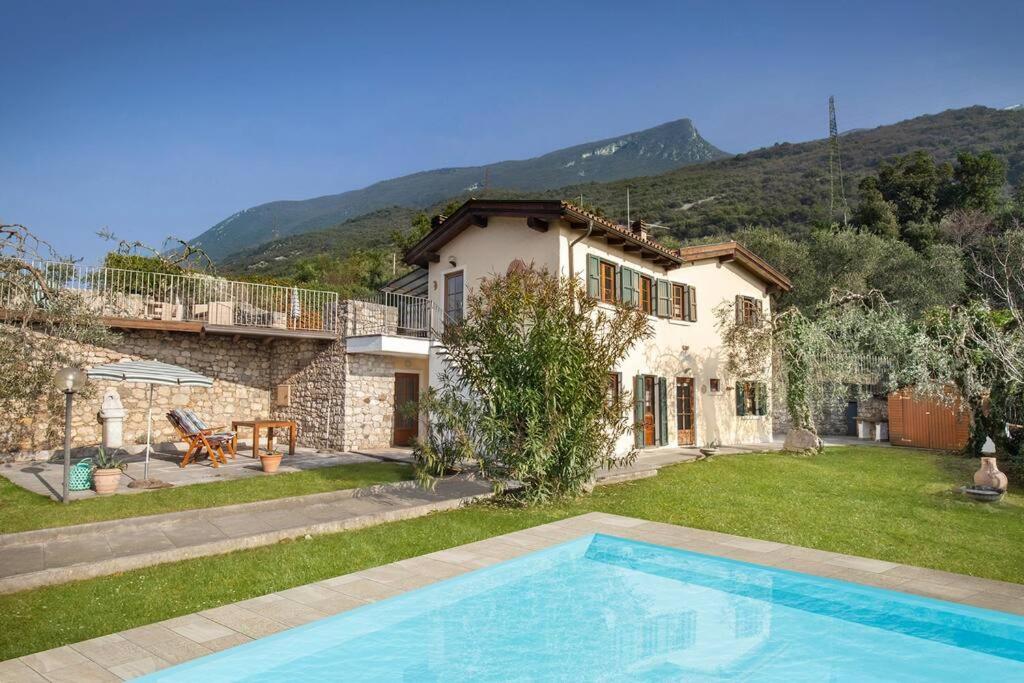 a villa with a swimming pool in front of a house at Villa Fuzzys - Un antico casale ristrutturato in Malcesine