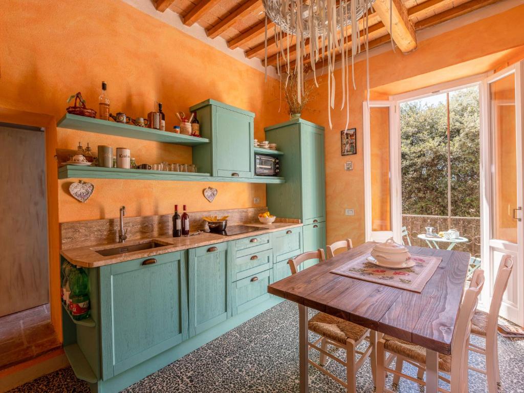 a kitchen with green cabinets and a wooden table at Apartment Trilocale dell'Arco by Interhome in Massa Marittima