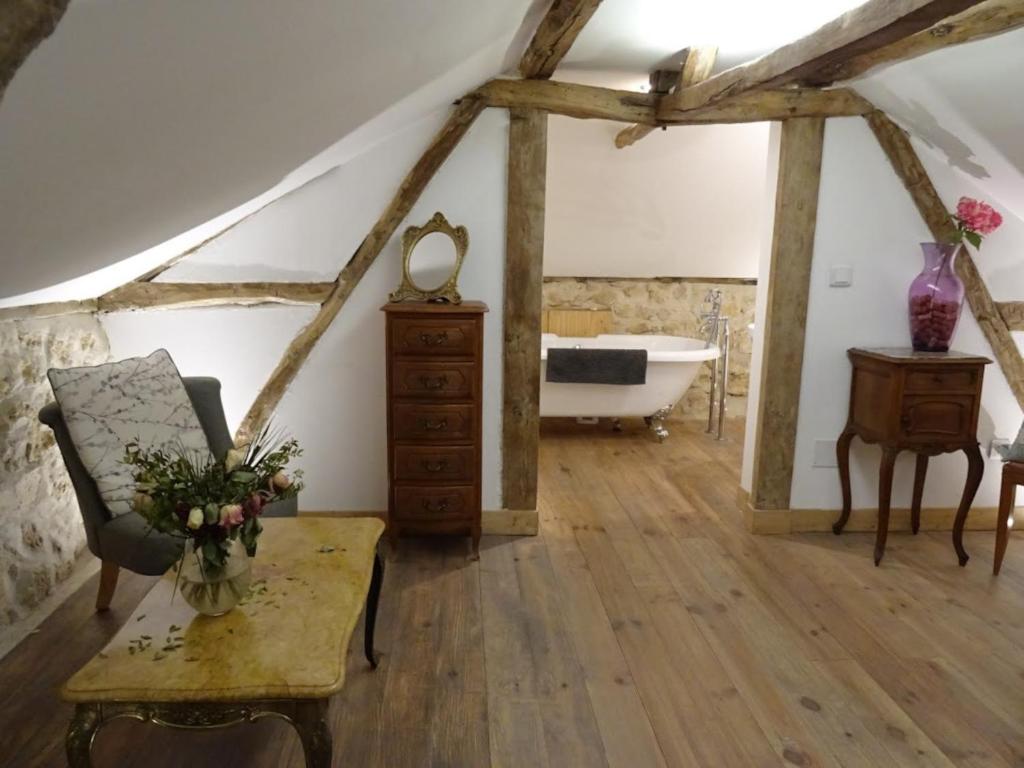 a room with a bath tub and a table and a chair at Le Moulin du Clapier La Banette in Sorges